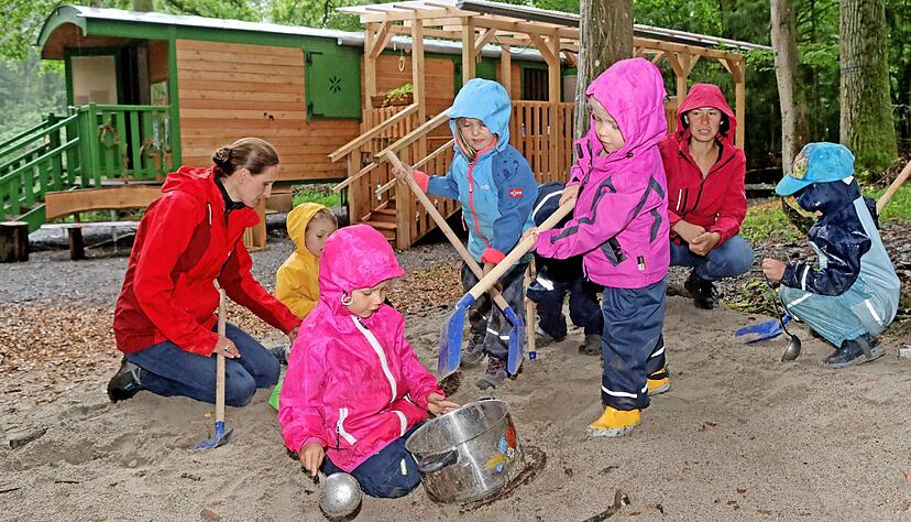 Bei Regen ist es noch sch&ouml;ner, im Sand zu spielen. Dann l&auml;sst sich so ein sch&ouml;ner Schlamm anr&uuml;hren. Mit dabei sind die Erzieherinnen Carolin Drautz-Scholz (links) und Anja Dietrich. Im Hintergrund die Unterkunft des Waldkindergartens.