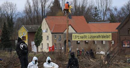 Klimaschutzaktivisten sitzen am Dorfrand von Lützerath.
