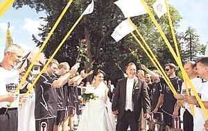 Rosen und Eckfahnen in die Luft: Nach der Trauung stehen die Fu&szlig;ballkameraden Spalier.Fotos: Andreas Veigel
