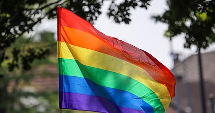Eine Regenbogenfahne weht im Wind.