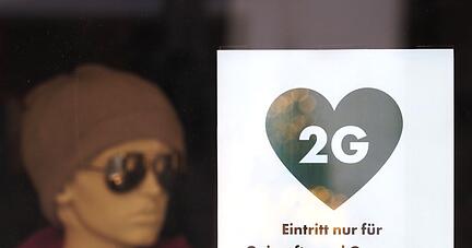 Ein Schild weist die Kunden eines Modegeschäfts in Potsdam auf die 2G-Regel hin.