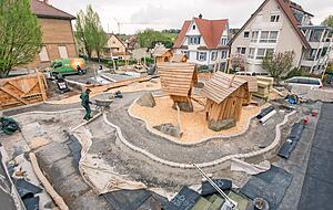 Die Rennbahn ist das Herzst&uuml;ck des Spielgartens mit seinen windschiefen H&uuml;tten und Wackersteinen. Robinie, Fels, Sand und Holzhackschnitzel sind die verwendeten Materialien.