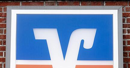 Das Logo der Volks- und Raiffeisenbanken h&auml;ngt &uuml;ber einer Gesch&auml;ftsstelle.
