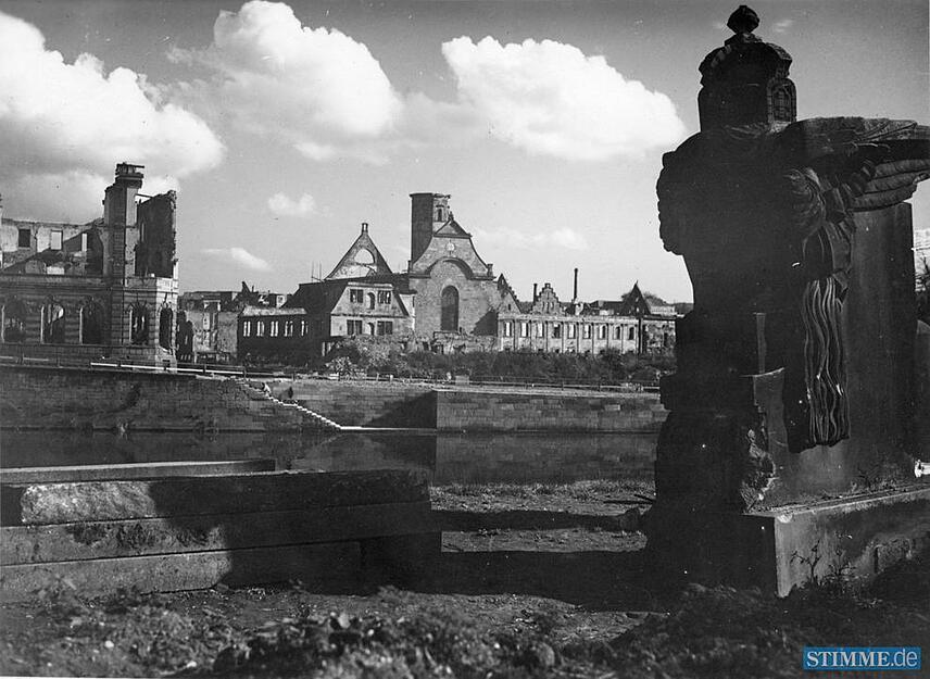 1945 blickt der Fotograf von der Neckarlust-Anlage (heute Kurt Schumacher Platz) und der geflügelten Germania, die dort das Bismarck Denkmal einrahmt, auf die gegenüberliegende Neckarseite und die Ruinen der Kirche St. Peter und Paul und des Deutschhofs . 1945 blickt der Fotograf von der Neckarlust-Anlage (heute Kurt Schumacher Platz) und der geflügelten Germania, die dort das Bismarck Denkmal einrahmt, auf die gegenüberliegende Neckarseite und die Ruinen der Kirche St. Peter und Paul und des Deutschhofs .
