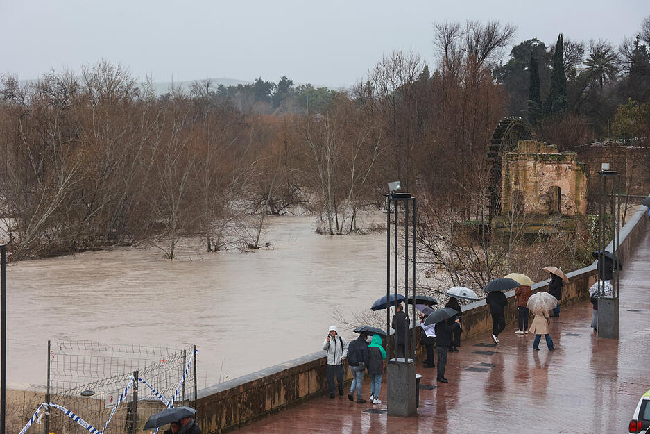 07.02.2026, Spanien, Cordoba (Andalusien): Menschen beobachten den angeschwollenen Guadalquivir-Fluss infolge des Sturms &laquo;Leonardo&raquo;. Das Sturmtief &laquo;Leonardo&raquo; hat S&uuml;dspanien mit Starkregen und Orkanb&ouml;en f&uuml;r &Uuml;berschwemmungen, Erdrutsche und erhebliche Sch&auml;den gesorgt. Foto: Roc&iacute;o Ruz/EUROPA PRESS/dpa +++ dpa-Bildfunk +++