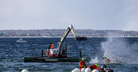 Ein Schwimmbagger arbeitet in der N&auml;he eines gestrandeten Buckelwals.