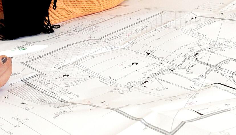 Eine Bauzeichnerin vor einem Bauplan. Die Bauindustrie fordert bessere digitale L&ouml;sungen f&uuml;r die Verwaltung.