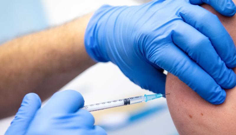 Die Mitarbeiterin einer Klinik wird gegen Corona geimpft.