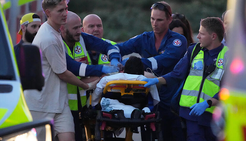 Rettungskräfte transportieren eine Person auf einer Bahre nach einem Zwischenfall am Bondi Beach in Sydney. Rettungskräfte transportieren eine Person auf einer Bahre nach einem Zwischenfall am Bondi Beach in Sydney.