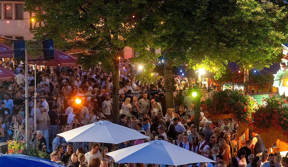 An den Ständen und unter Schirmen genießen die Besucher ihre Weine.
