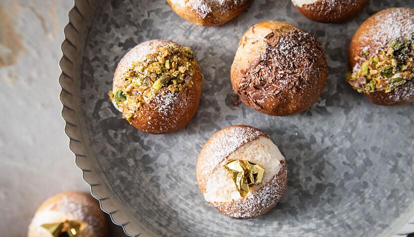 Diese fluffigen Milchbrötchen mit Cremefüllung werden Maritozzo Romano genannt. Sterneküchenmäßig werden sie mit Blattgold, Schokolade und Pistazien dekoriert. Diese fluffigen Milchbrötchen mit Cremefüllung werden Maritozzo Romano genannt. Sterneküchenmäßig werden sie mit Blattgold, Schokolade und Pistazien dekoriert.