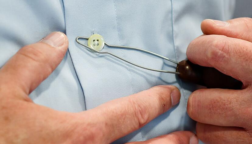 Kleiner Knopf, gro&szlig;es Gefriemel: Eine Kn&ouml;pfhilfe erleichtert es Parkinson-Erkrankten, das Hemd zu schlie&szlig;en.