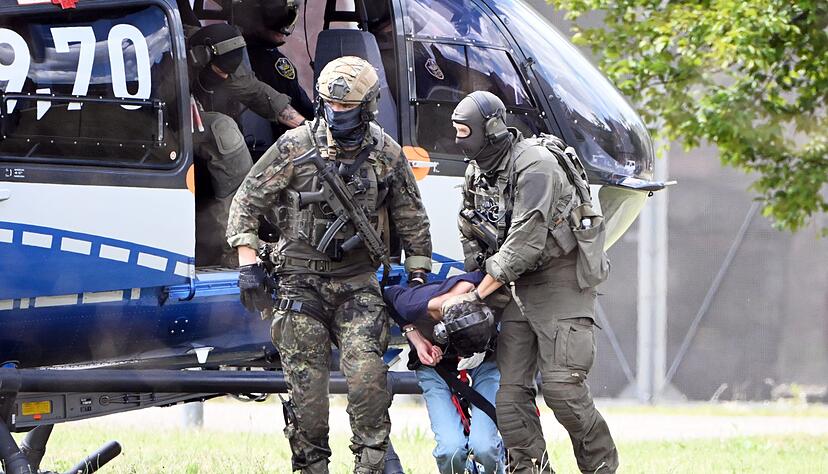 Der mutmassliche Täter des Messerangriffs von Solingen wird von einem Hubschrauber zu einer Wagenkolonne geführt. Er soll dem Ermittlungsrichter des Bundesgerichtshof (BGH) vorgeführt werden, der über einen Haftbefehl entscheiden wird.