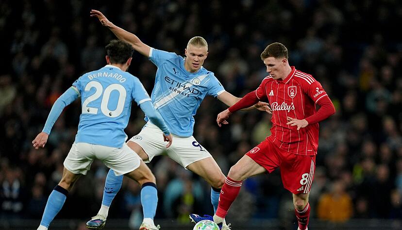 Nottinghams Torsch&uuml;tze Elliot Anderson (r) im Zweikampf mit Erling Haaland (M) und Bernardo Silva.
