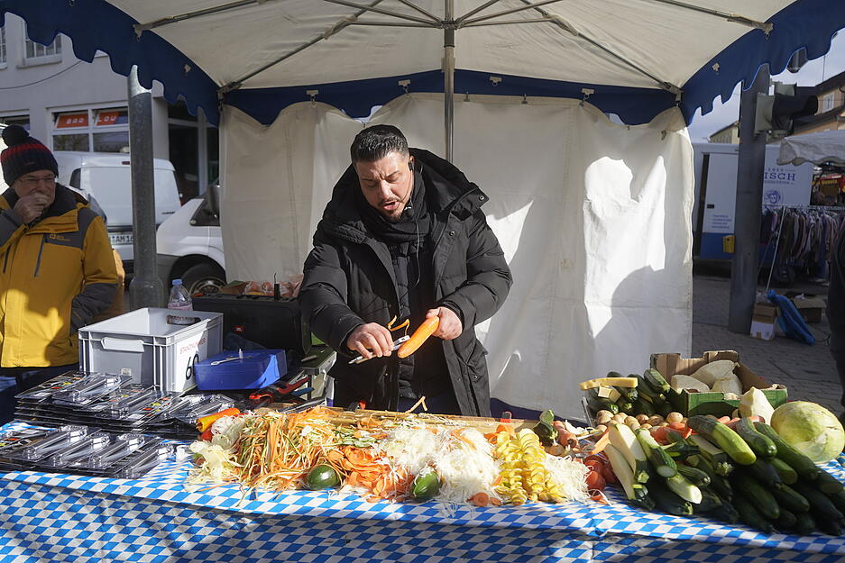 Besucher bummeln zwischen Kr&auml;merst&auml;nden und historischen Geb&auml;uden durch die Stadt.