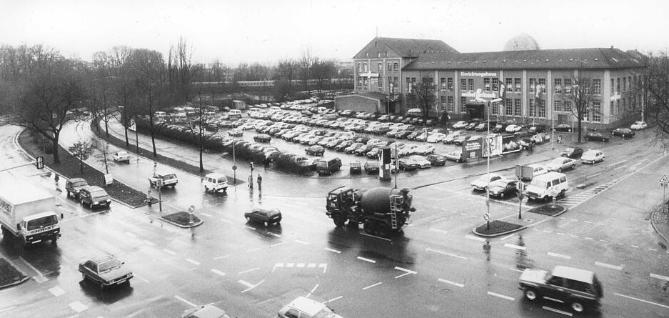 Nach dem Abriss der Gebäude war das planierte Areal über zehn Jahre ein begehrter, kostenfreier Parkplatz. Im Hintergrund ist das Einrichtungshaus Möbel Fritzsch im Backsteinbau sichtbar. Für einen Neubau muss der Parkplatz teilweise weichen. Aufnahme aus dem Jahr 1992.