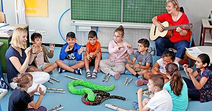 Viel Freude haben die Kinder mit Antje Harloff von der Städtischen Musikschule Heilbronn, die mit ihrer Gitarre morgens in die Klasse kommt. Lehrerin Franciska Ehresmann (links) ist auch dabei.
Foto: Ralf Seidel