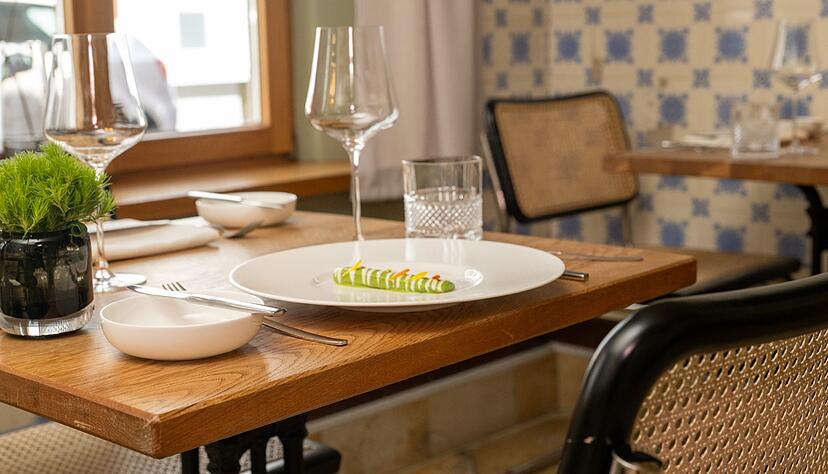 Ein Teller mit Essen steht im Sternerestaurant bi:braud auf einem unbesetzten Tisch. Ein Teller mit Essen steht im Sternerestaurant bi:braud auf einem unbesetzten Tisch.