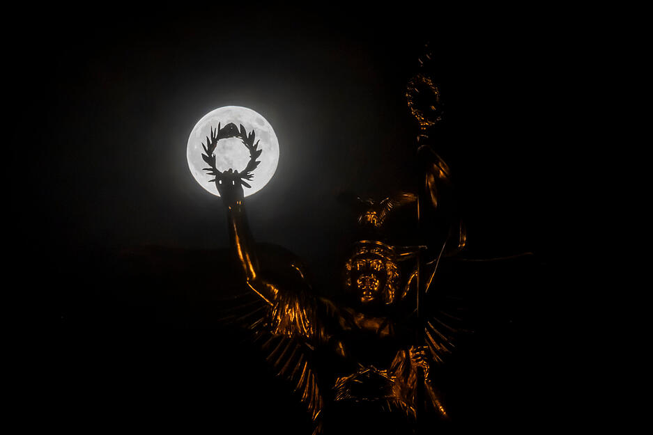 Der Vollmond ist hinter dem Lorbeerkranz der Viktoria "Goldelse" auf der Siegessäule zu sehen. Der Vollmond ist hinter dem Lorbeerkranz der Viktoria "Goldelse" auf der Siegessäule zu sehen.