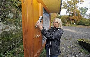 Andrea Siebel bestückt die Tafel am Parkplatz mit Infomaterial.