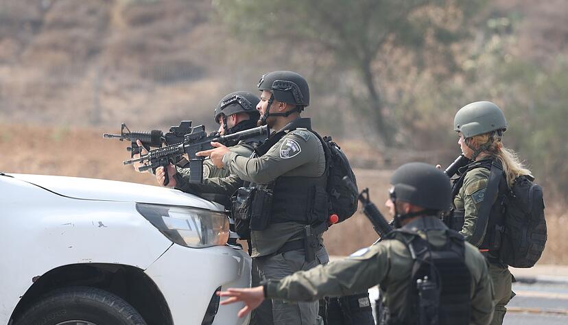Israelische Streitkräfte gehen hinter einem Fahrzeug in Sderot in Stellung.