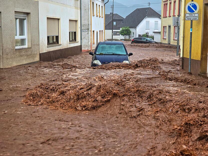 Ein Auto bahnt sich den Weg durch die Wassermassen in Kirn.