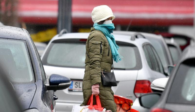 Eine Frau mit Mundschutz auf dem Parkplatz eines Einkaufszentrums in Salzburg.