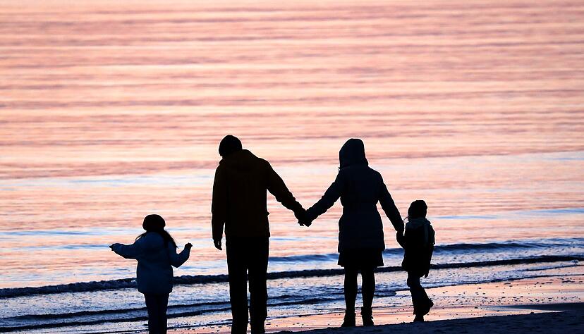 Eine Familie mit zwei Kindern am Strand. (Symbolbild)