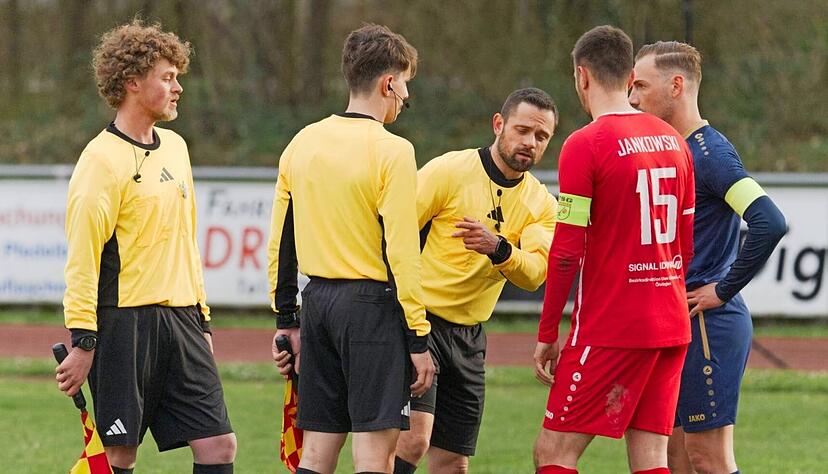 Schiedsrichter Dominik Englmann (Mitte) erkl&auml;rt im Beisein seiner Assistenten Oskar Klau&szlig; (li.) und Adrian Benzenh&ouml;fer, den Kapit&auml;nen, &Ouml;hringens Yannick Jankowski und Neckarsulms Mattia Trianni, warum es nicht weitergeht.
Foto: Michael Nachreiner