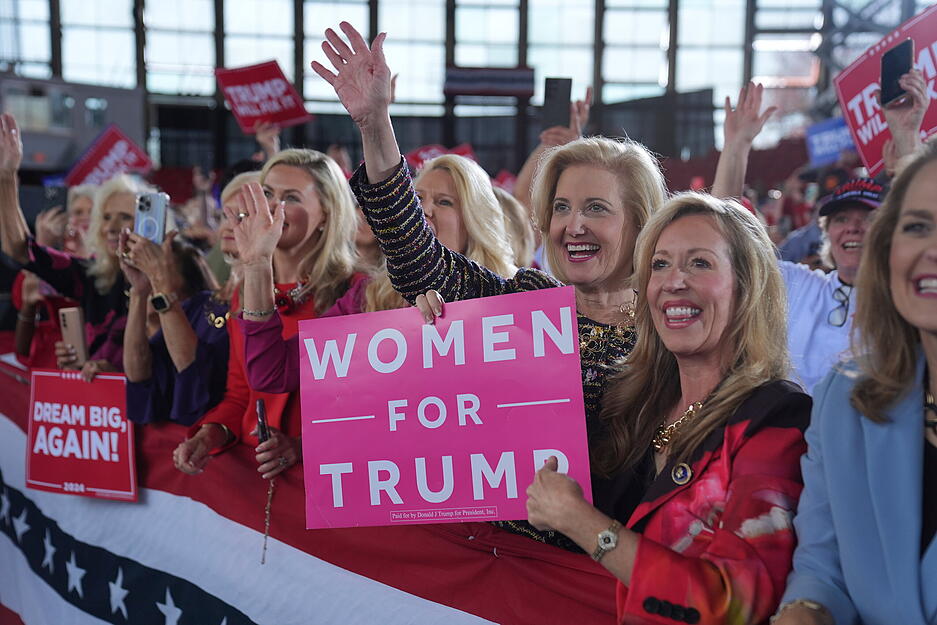 04.11.2024, USA, Raleigh: Anhängerinnen des republikanischen Präsidentschaftskandidaten und früheren US-Präsidenten Donald Trump jubeln ihm zu während einer Wahlkampfveranstaltung in der J.S. Dorton Arena.