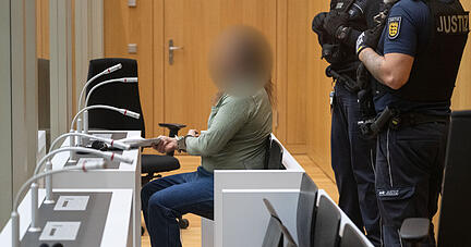 Der Angeklagte in einem Staatsschutzverfahren sitzt in einem Saal des Oberlandesgerichts Stuttgart. Der mutmaßliche «Reichsbürger» soll vor einem Jahr im badischen Boxberg mit einem Schnellfeuergewehr auf die Beamten geschossen und zwei von ihnen verletzt haben, weil sie seine Wohnung durchsuchen wollten. Dem Mann wird mehrfacher versuchter Mord zur Last gelegt, verhandelt wird im streng gesicherten OLG-Prozessgebäude Stammheim.