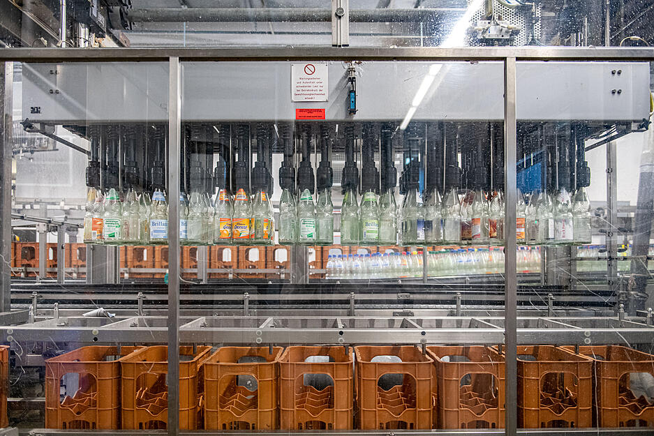 Das Leergut wird über Transportbänder in eine Maschine geschickt, wo es bei etwa 85 Grad Celsius gewaschen wird.