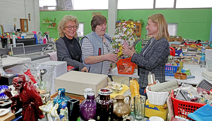 Die Politikerinnen Beate Müller-Gemmeke (links) und Gudula Achterberg (rechts) mit Birgit Schenk, die die gespendeten Waren fürs Kaufhaus prüft und säubert. Foto: Ralf Seidel