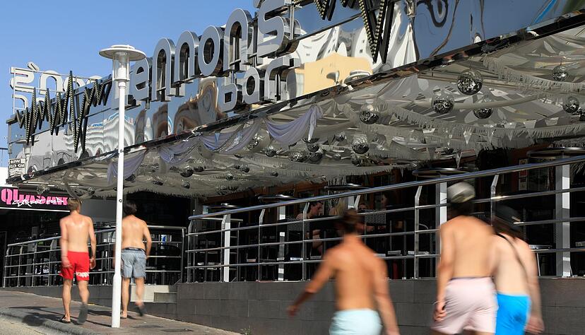 Junge M&auml;nner gehen mit nacktem Oberk&ouml;rper auf Mallorca spazieren. (Archivbild)