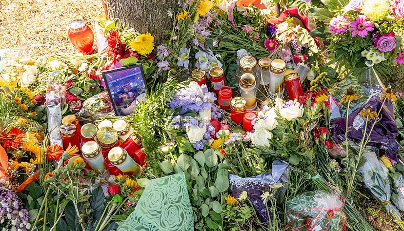Blumen, Kerzen und Bilder liegen an einem Baum, in dessen Nähe am 17. August 2022 eine Leiche in einem Pkw entdeckt wurde. Blumen, Kerzen und Bilder liegen an einem Baum, in dessen Nähe am 17. August 2022 eine Leiche in einem Pkw entdeckt wurde.