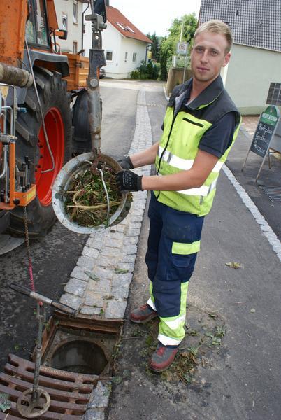 Der Einlaufschacht eines Kanals in Ilsfeld wird von Blättern gereinigt.