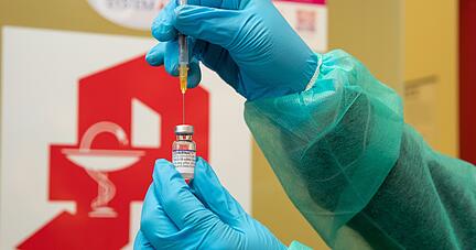 Eine Apothekerin zieht den Impfstoff Comirnaty vom Hersteller Biontech / Pfizer mit einer Spritze auf. Eine Apothekerin zieht den Impfstoff Comirnaty vom Hersteller Biontech / Pfizer mit einer Spritze auf.