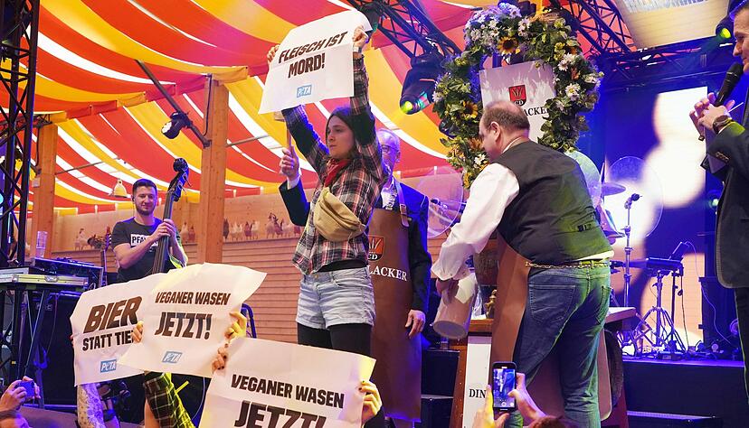 Aktivisten von Peta stören beim Stuttgarter Frühlingsfest den Fassanstich und halten Plakate hoch. Aktivisten von Peta stören beim Stuttgarter Frühlingsfest den Fassanstich und halten Plakate hoch.