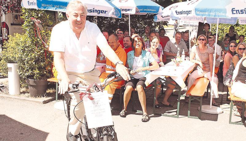 Zur Freude seiner Mitabeiter dreht Helmut M. Jahn eine erste Runde mit dem E-Bike, das er als Abschiedsgeschenk bekommen hat. Einen Wegweiser Richtung Hohenlohe gab es zudem, damit er auch künftig stets den Weg findet.
Fotos: Matthias Stolla