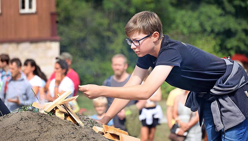 Mehr als 100 Besucher verfolgen, wie Jungköhler Silas Claas (13) gemeinsam mit Herbert Haag den Meiler anzündet. Mehr als 100 Besucher verfolgen, wie Jungköhler Silas Claas (13) gemeinsam mit Herbert Haag den Meiler anzündet.