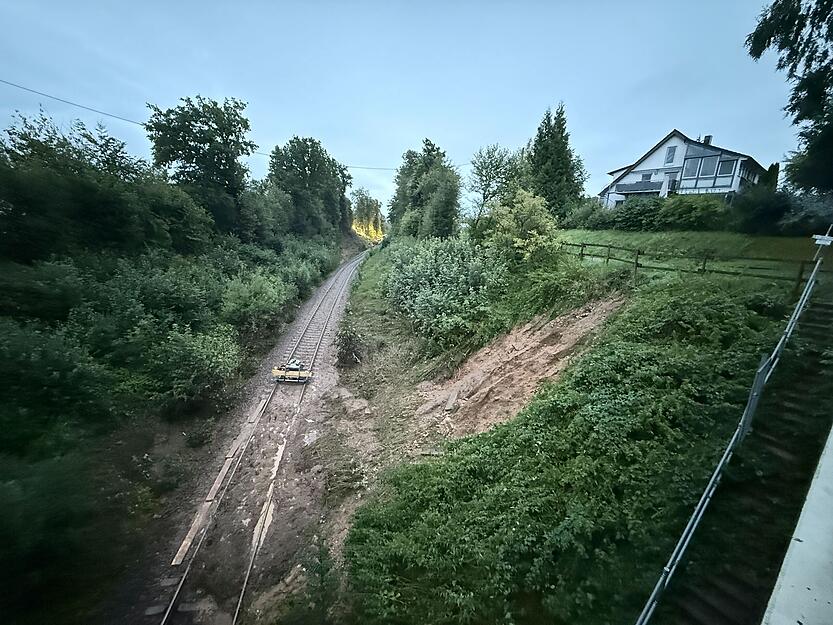 Erde liegt nach einem Hangrutsch auf den Gleisen. Der Regionalexpress ist im Kreis Biberach zwischen den Ortsteilen Zweifaltendorf und Zell entgleist.