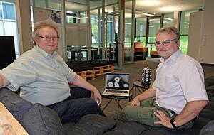 Ralph und Frederik Wystup im Digital Hub in K&uuml;nzelsau. Auf dem Monitor sind Coronaviren zu sehen, die mit einem Elektronenmikroskop fotografiert wurden.
Foto: Gleichauf