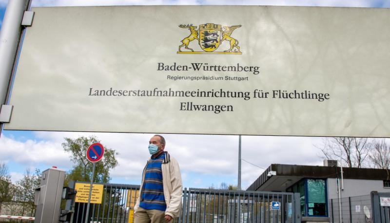 Am Eingang zur Landeserstaufnahmeeinrichtung für Flüchtlinge (LEA) geht ein Mann mit Maske vorbei.