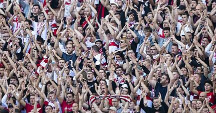 Fans des VfB Stuttgart stehen im Fanblock.
