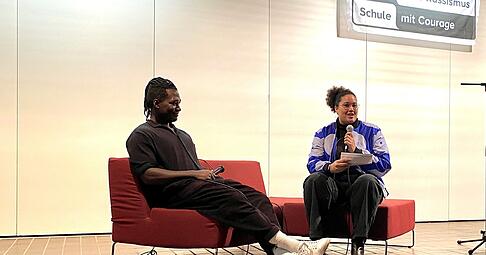 „Wir wissen viel zu wenig über Afrika“: Der „Afrofluencer“ Stève Hiobi in der Aula des Hartmanni-Gymnasiums im Gespräch mit der Lehrerin Nella Ruder. „Wir wissen viel zu wenig über Afrika“: Der „Afrofluencer“ Stève Hiobi in der Aula des Hartmanni-Gymnasiums im Gespräch mit der Lehrerin Nella Ruder.