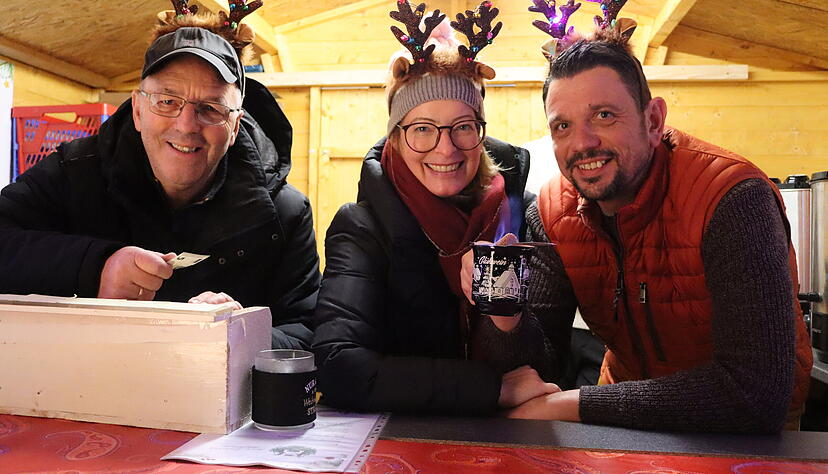 &bdquo;Frohsinn&ldquo; ist ihr Motto: (Von links) Clemens Treffert, Anne W&uuml;nst und Stefan Friedrich vom gleichnamigen M&auml;nnergesangverein verkaufen Feuerzangenbowle.