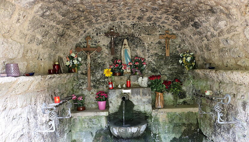 In Neusa&szlig; flie&szlig;t unweit der Wallfahrtskirche Quellwasser in ein Becken. Dar&uuml;ber wacht eine Madonnenstatue.