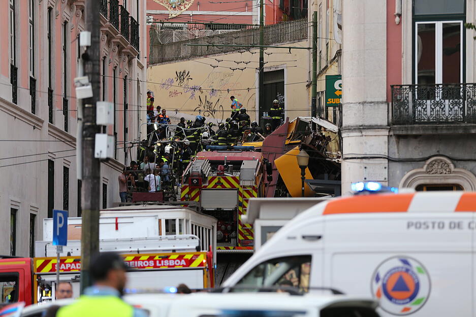 Rettungskräfte arbeiten in Lissabon an der Stelle, an der eine Standseilbahn entgleist ist. Der Unfall des auch bei Touristen beliebten "Elevador da Gloria" hat sich am Mittwochabend aus noch unbekannter Ursache ereignet.