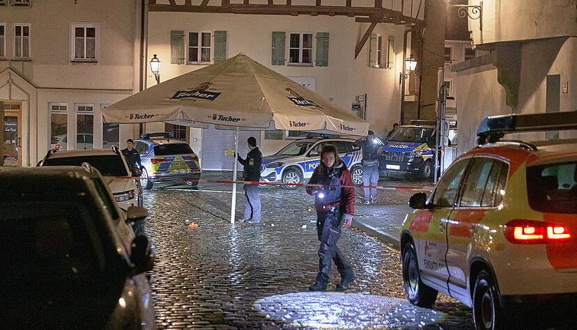 Polizisten suchen in der Innenstadt von Ansbach den Tatort ab.