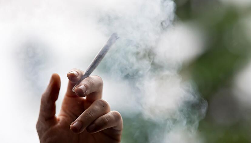 Ein Mann hält einen Joint in der Hand. Ein Mann hält einen Joint in der Hand.